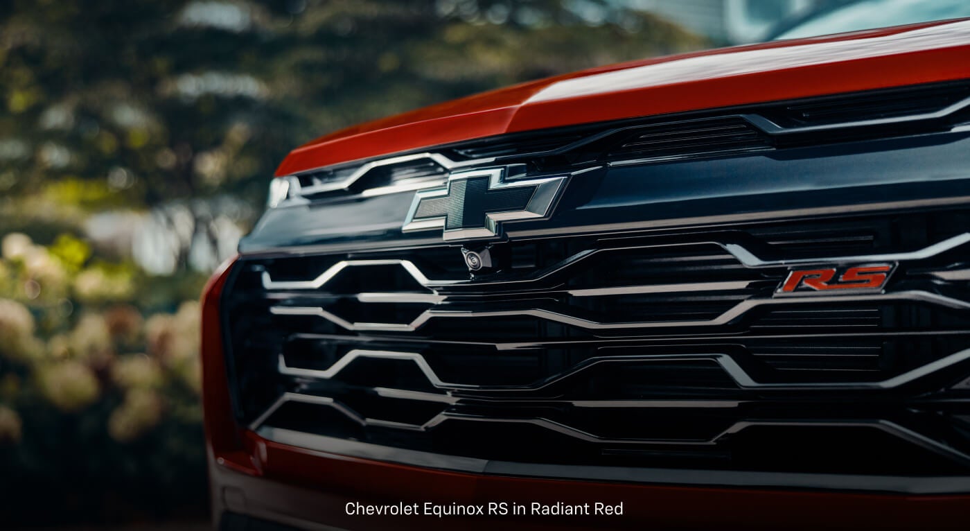 Close-up view of a Chevrolet Equinox RS in Red showcasing the black mesh grille and RS emblem.