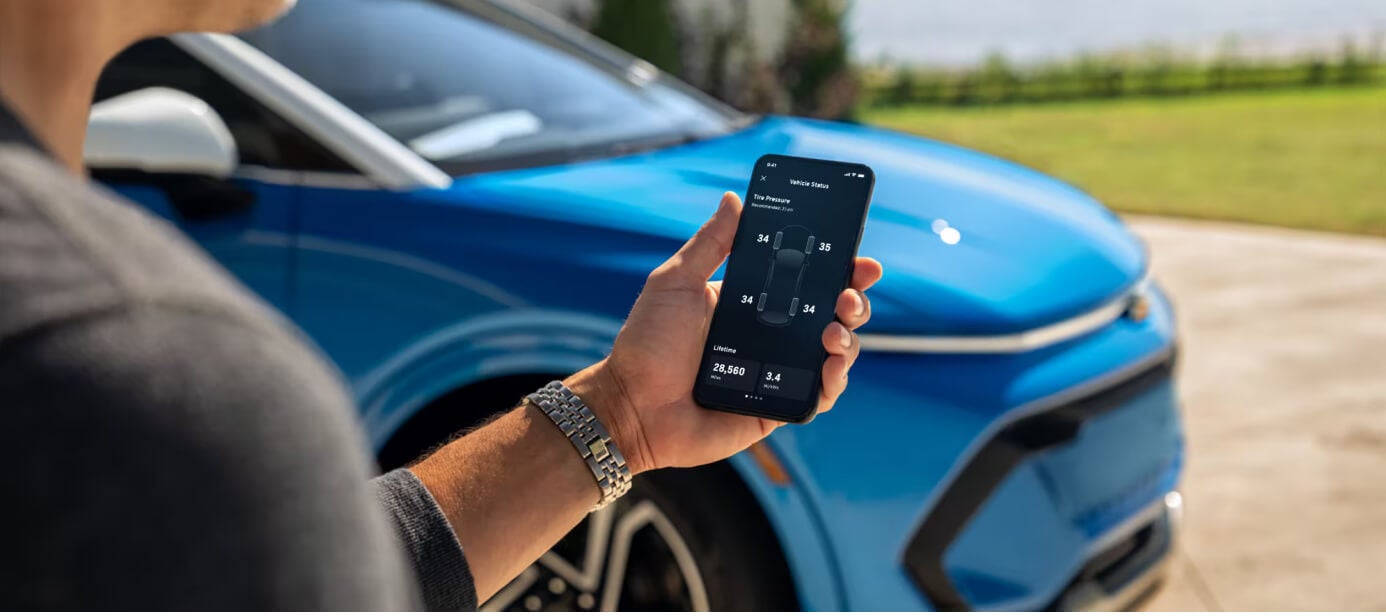 Close-up view of a driver using the myChevrolet app to check tire pressure on an Equinox.