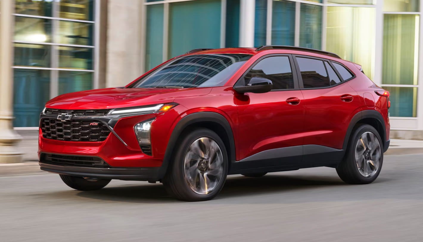 Red Chevrolet Trax SUV driving through a city street.