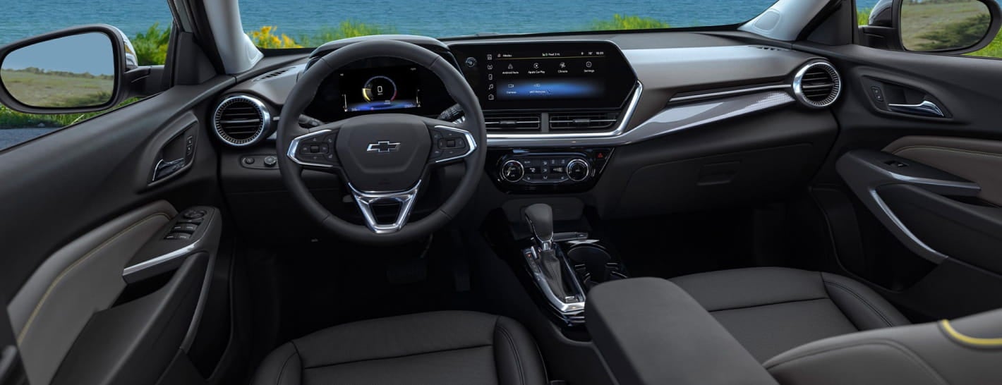 View of the Chevrolet Trax cabin featuring the driver-focused dashboard, digital displays, center touchscreen and front seating.